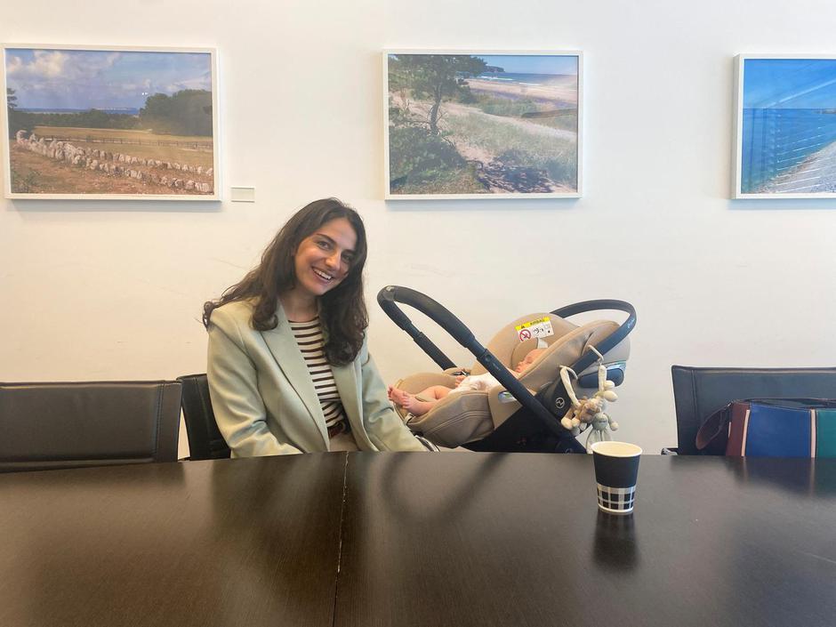 Swedish environment minister Romina Pourmokhtari sits in a meeting room with her baby, at a meeting of EU climate ministers in Luxembourg | Author: KATE ABNETT/REUTERS