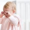 Tired baby girl crying and rubbing her eyes