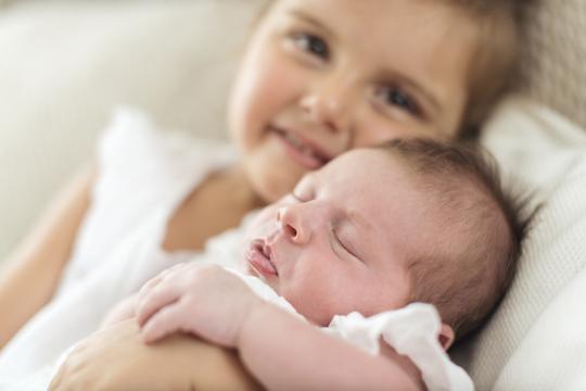 novorođenče dijete drži 