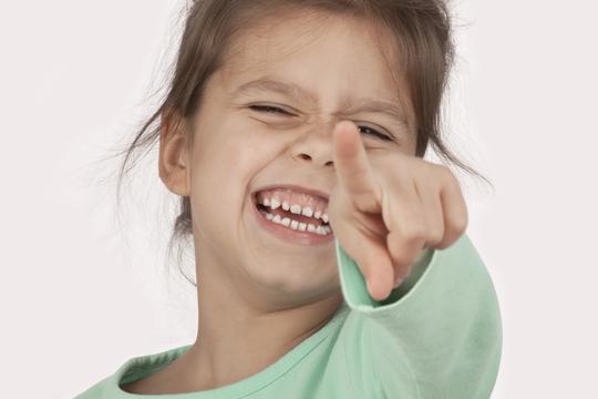 djevojčica pokazuje prstom smijeh